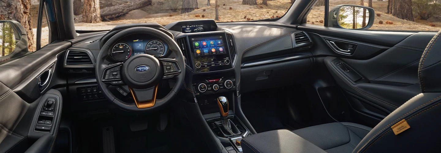 Intedrior view of the dashboard and tech of a 2025 Subaru Forester in the woods of Nederland, TX