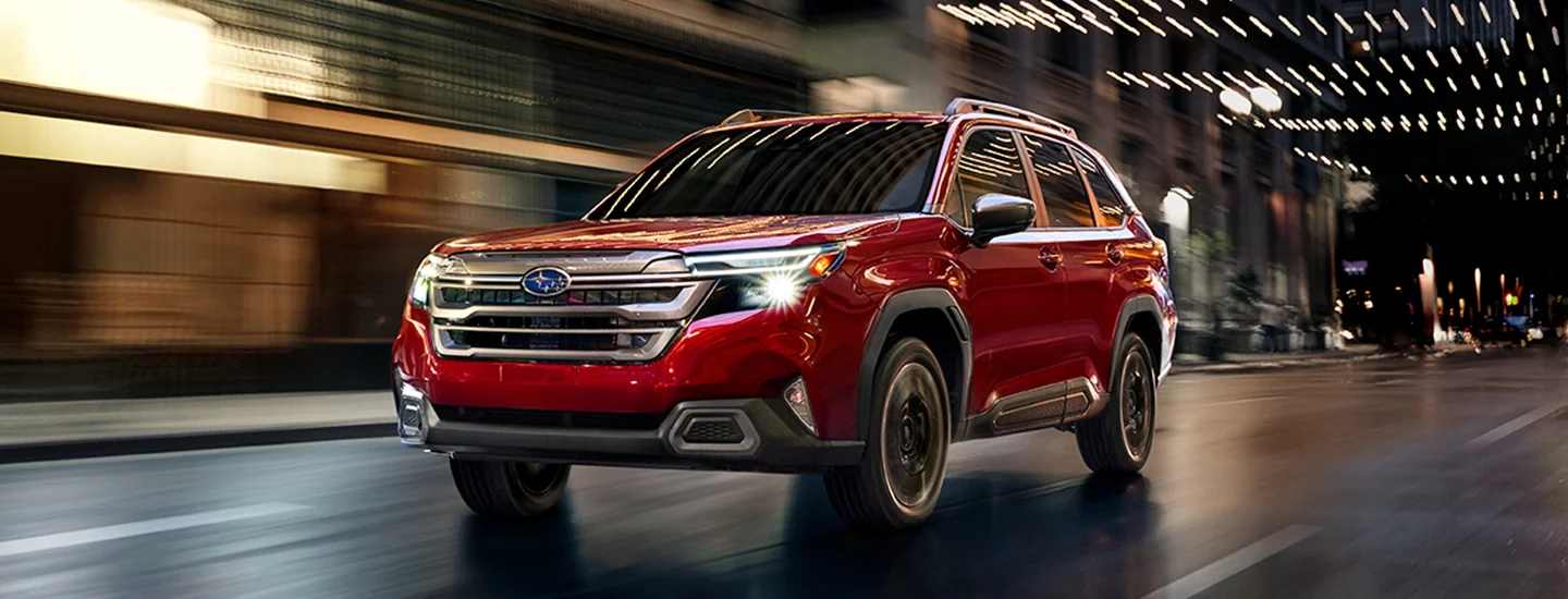 Front view of a red 2026 Subaru Forester driving in the city