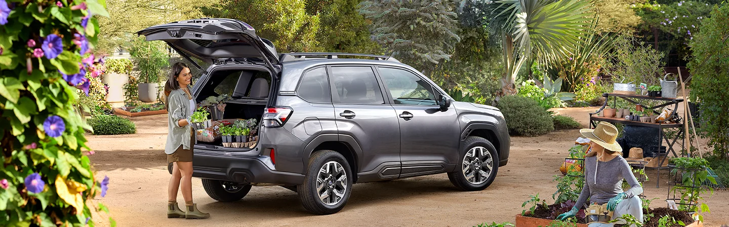 Back view foa gray 2026 Subaru Forester with the truck opened and a person loading up flowers