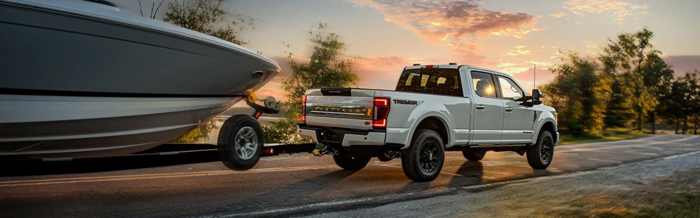 white Ford truck pulling boat