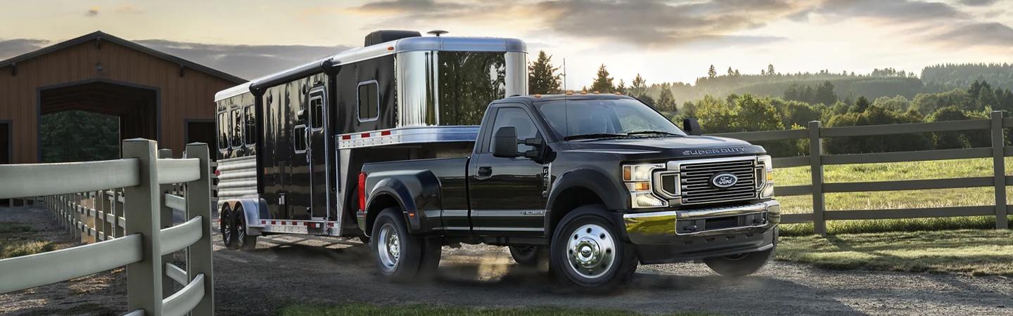 black Ford truck pulling horse trailer