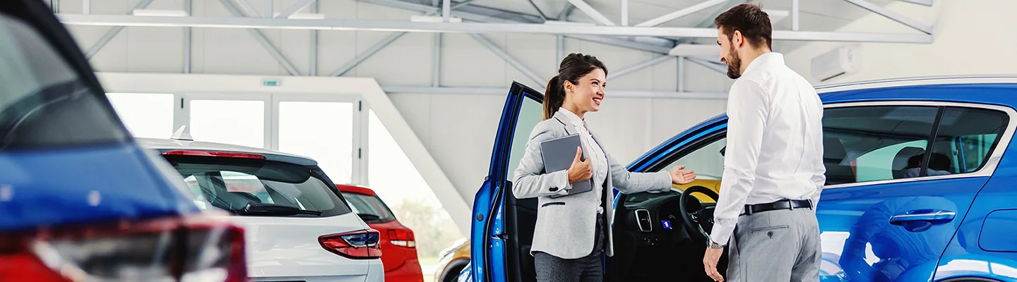 sales woman showing guy the interior of the car