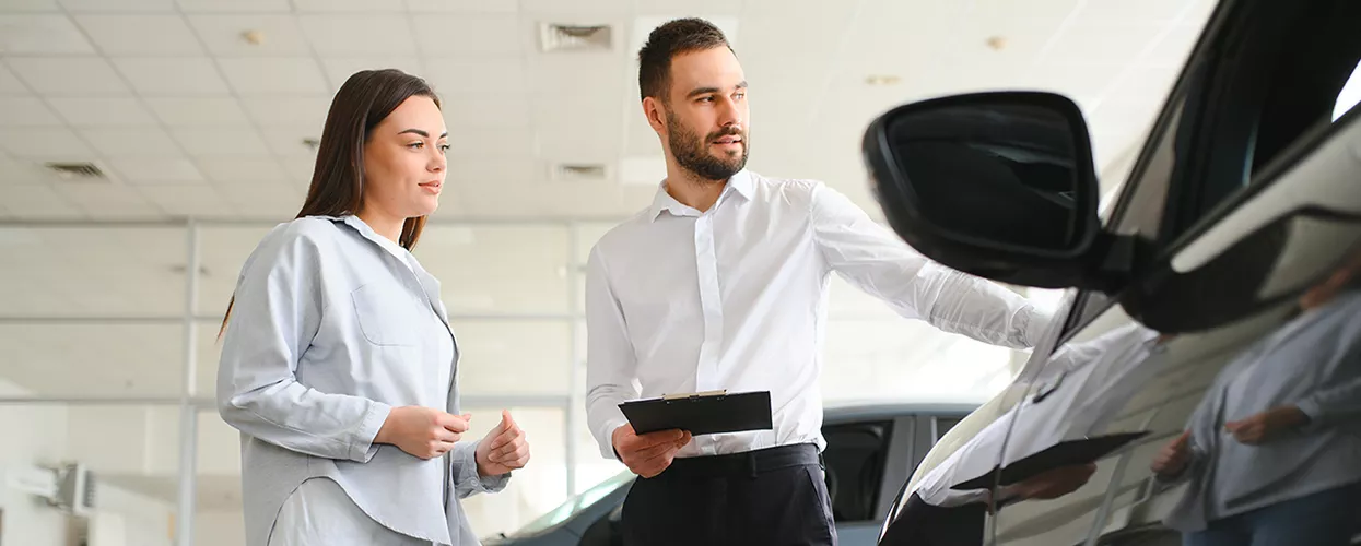 Car salesman showing a customer a new vehicle