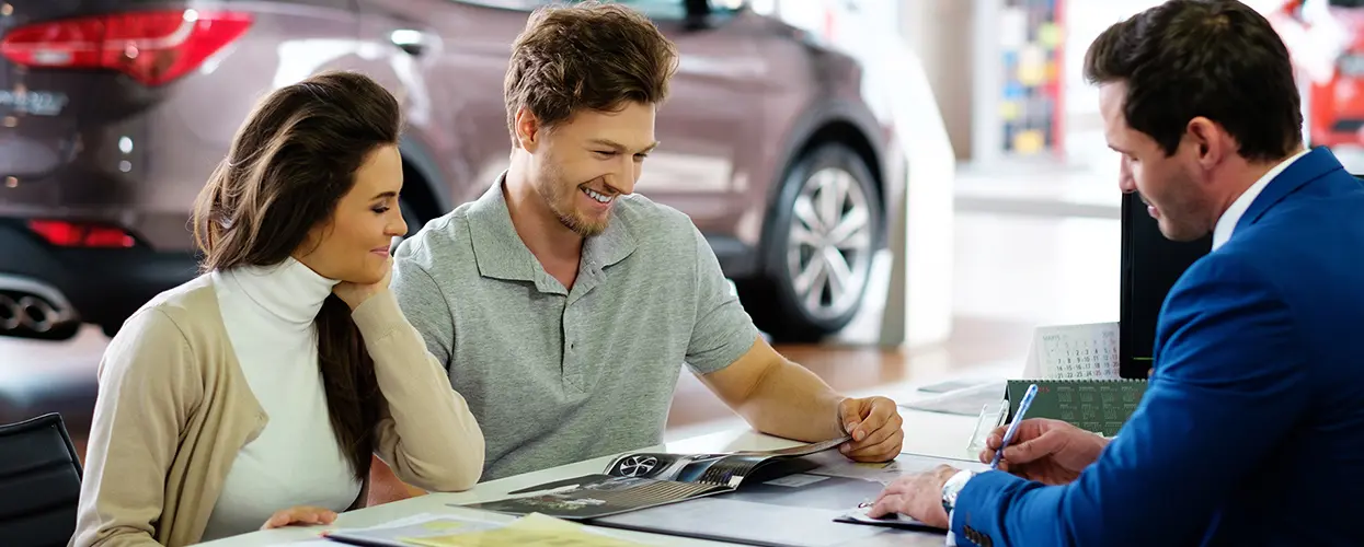 brother and sister in showroom car shopping