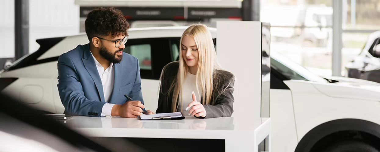 Customer talking to a car salesman in a car dealership