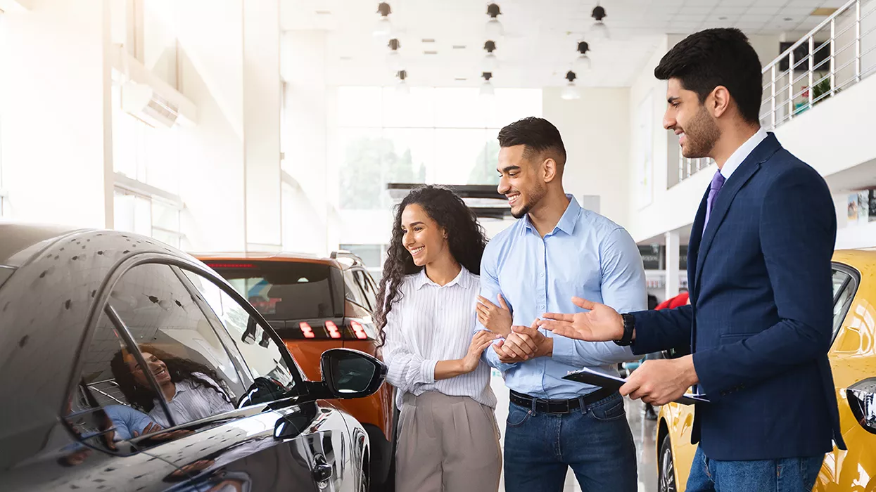 A car salesman talking to a couple about a car