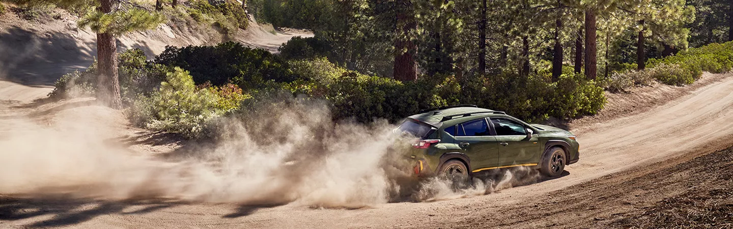 2026 Subaru Crosstrek driving on a dirt road with dust kicking up