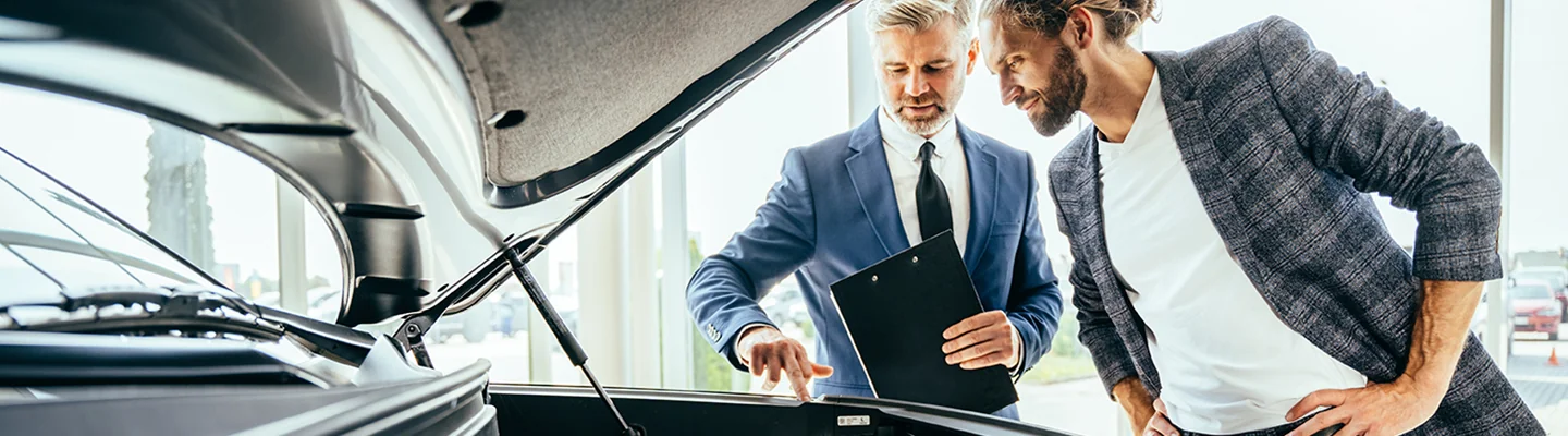 Car salesperson showing the engine of a vehicle to a customer in Tyler, TX