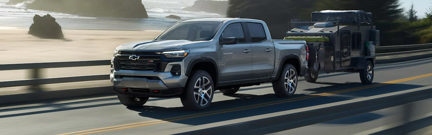Silver 2024 Chevrolet Colorado pulling a trailer of ATVs