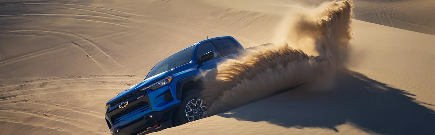 A blue 2024 Chevrolet Colorado driving in the sand