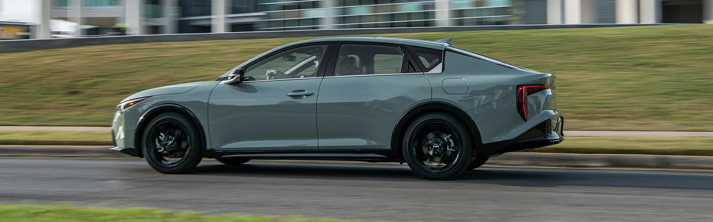 Side view of a 2025 Kia K4 driving in the city