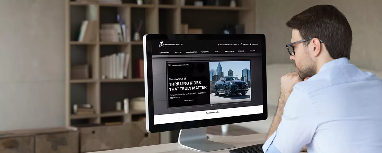 Man using his computer to look at the Lamborghini Charlotte website