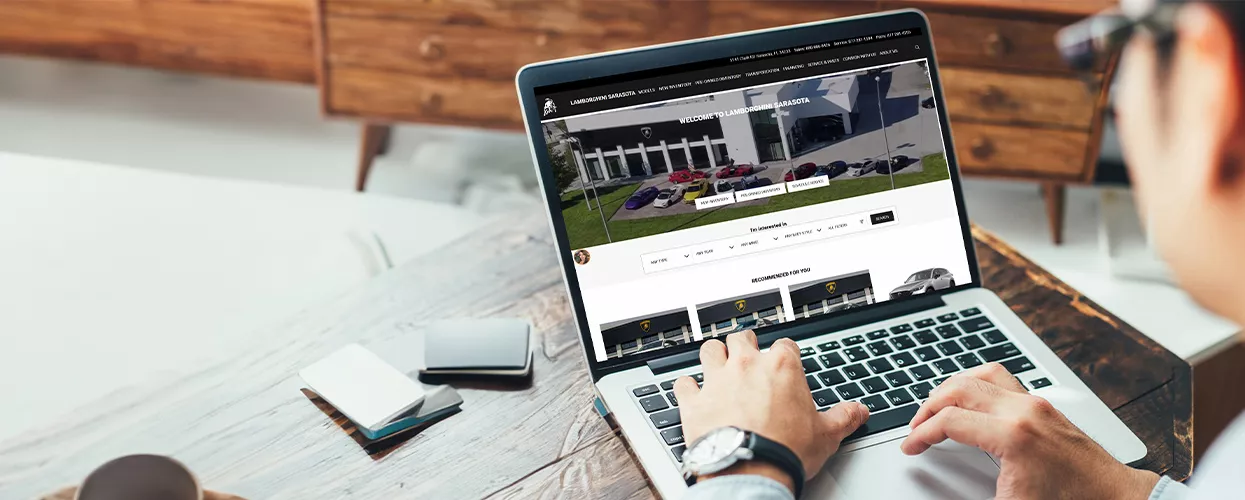 Person using a computer to view the Lamborghini of Sarasota website