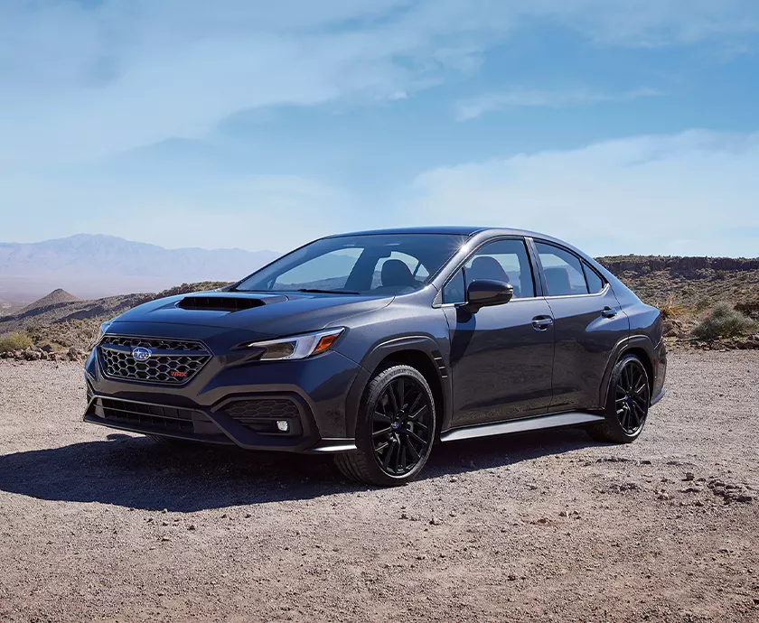 dark blue fronr view of a Subaru WRX parked on at a gravel scenic overlook