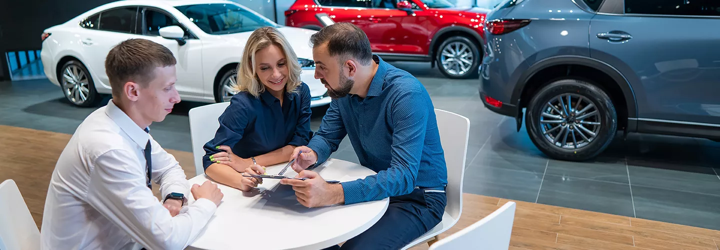 salesman with man and woman in the dealership