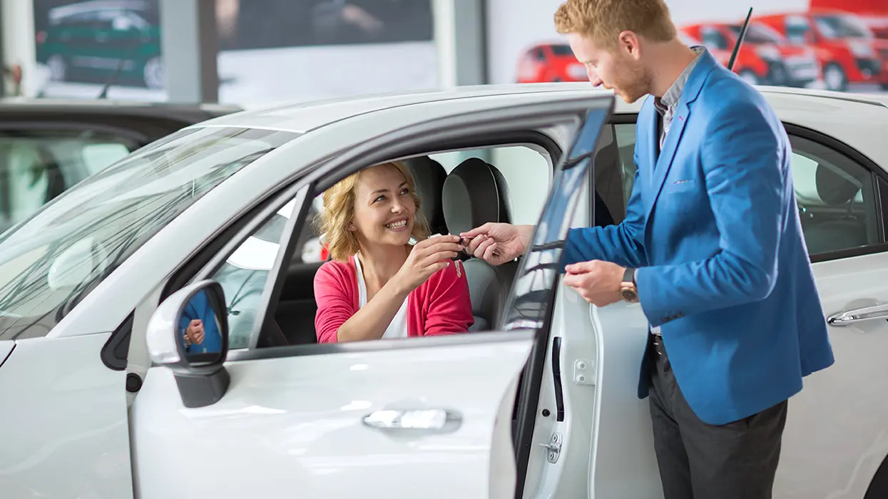 salesman with keys for new car
