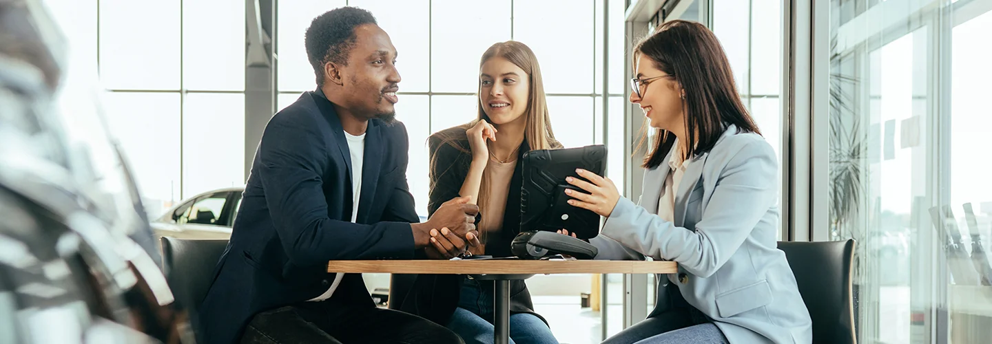 Sales person helping customers looking at car options