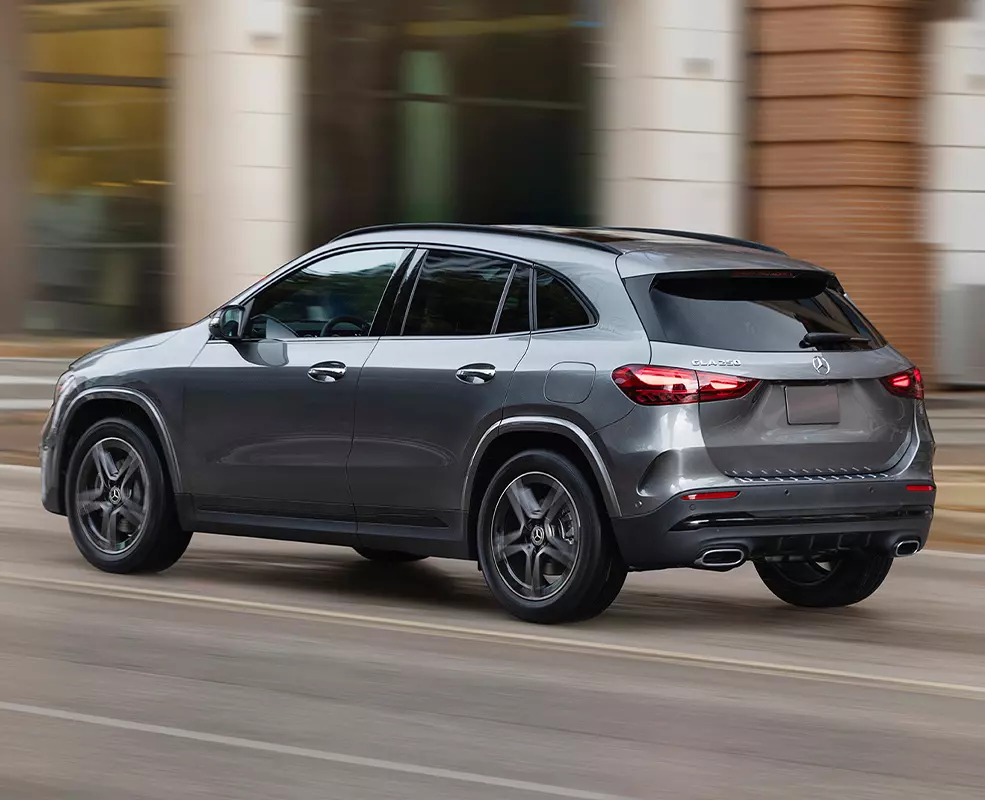 Back side view of a gray 2026 Mercedes-Benz GLA driving in the city