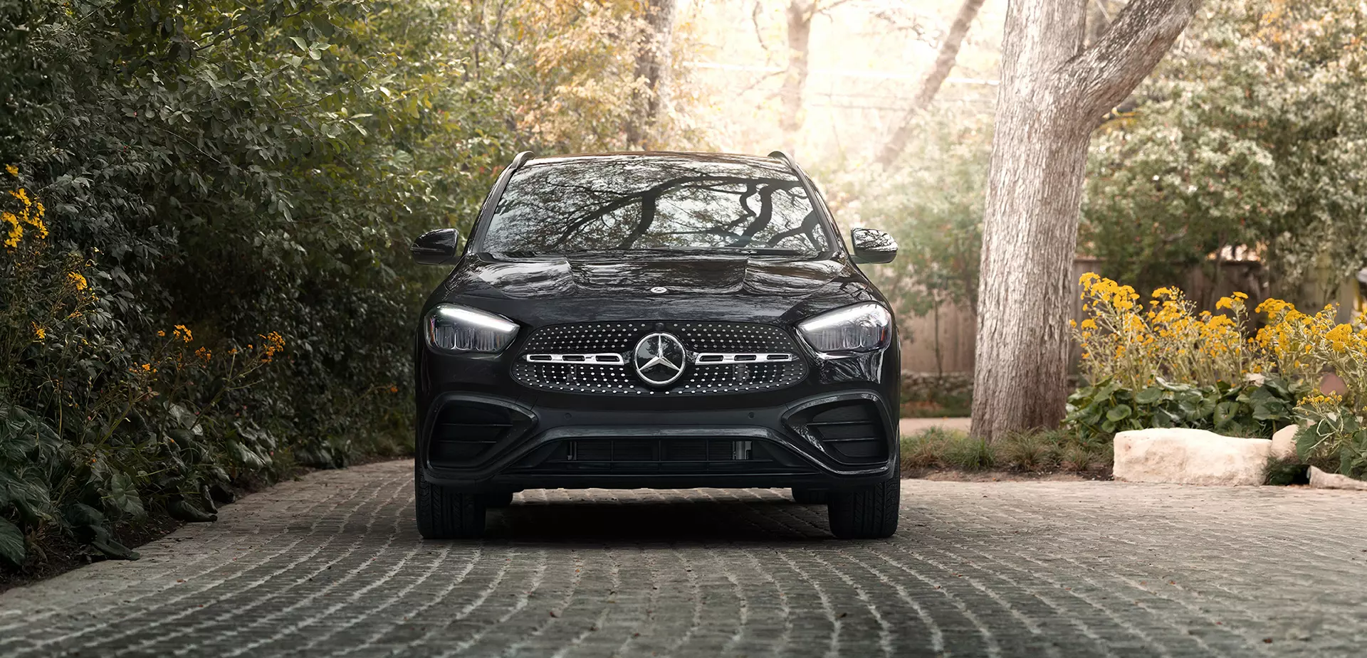 A front view of a parked black 2026 Mercedes-Benz GLA in a driveway