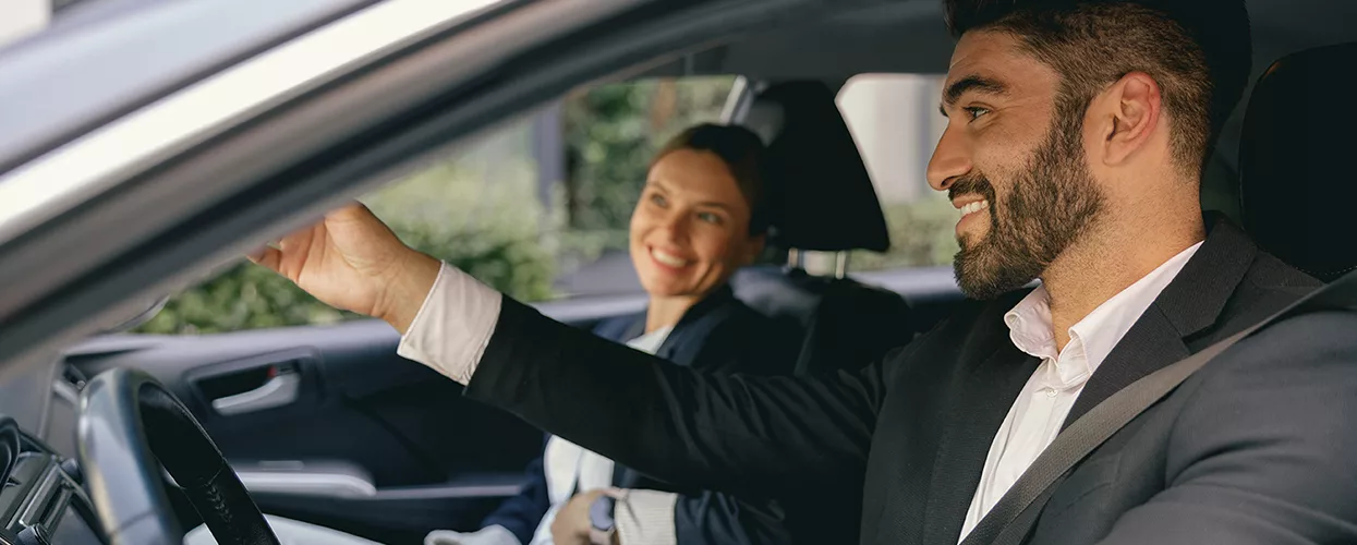 Car salesman showing a customer the interior of a new vehicle