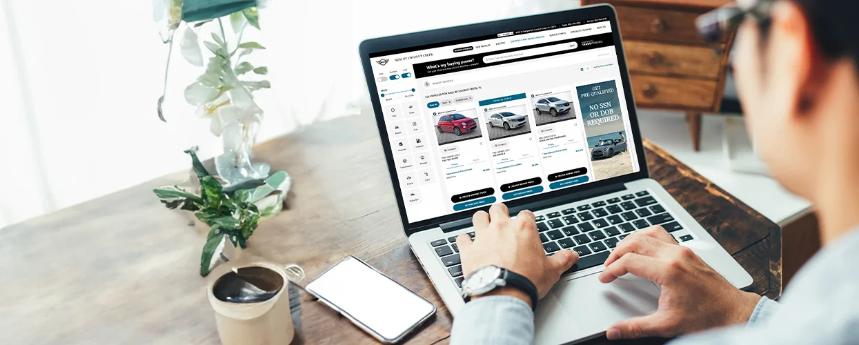 a view of hands on a laptop browsing the MINI of Coconut Creek website shopping online