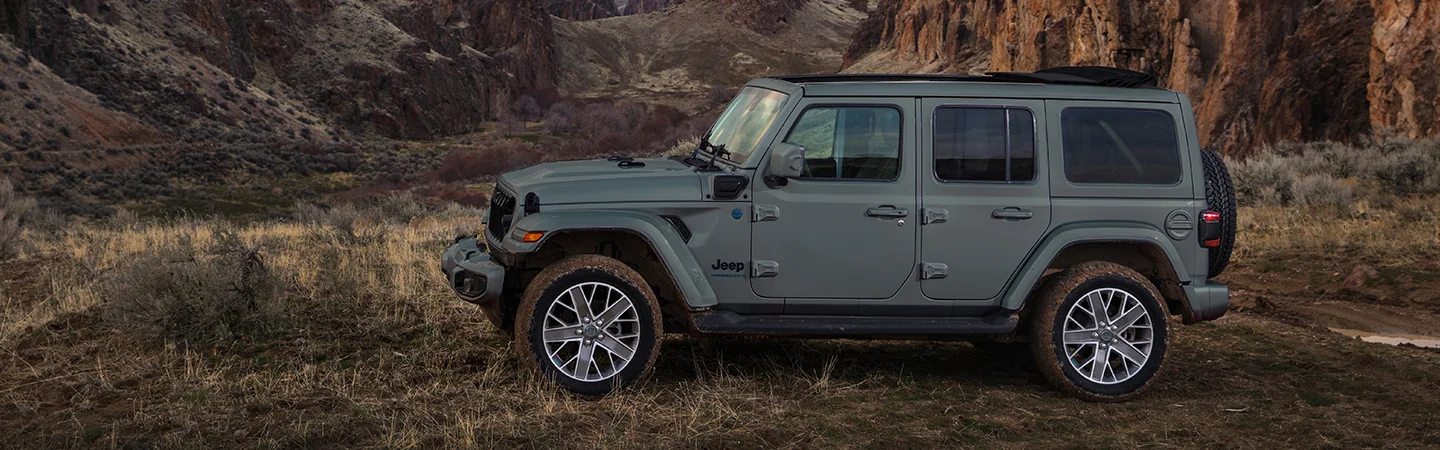 Side view of a parked 2025 Jeep Wrangler in the wilderness