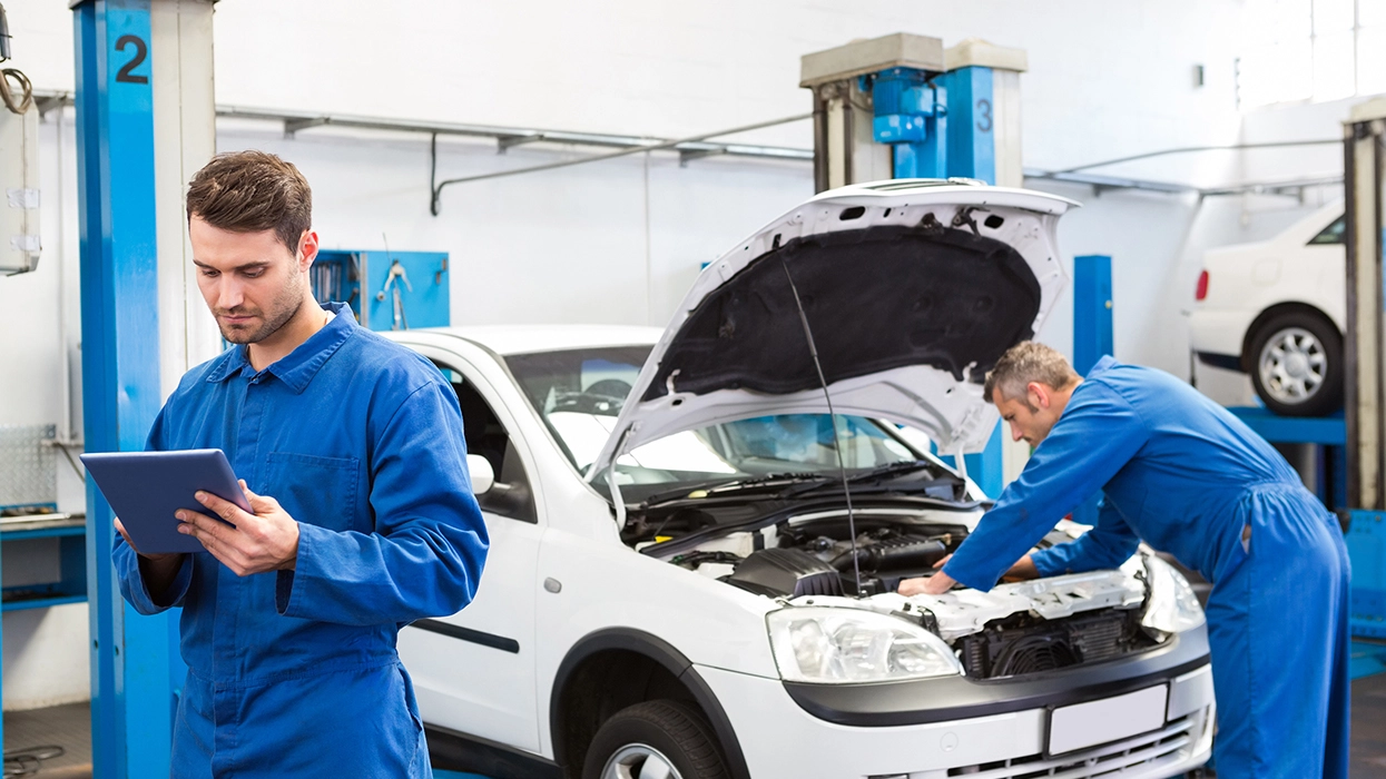 Mechanics working under the hood of a car