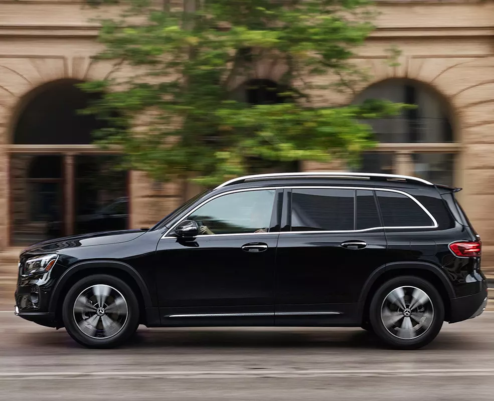 Side view of a 2026 Mercedes-Benz GLB driving in the city