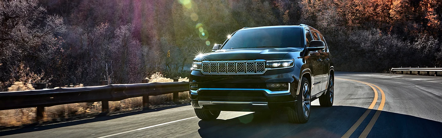 2025 Grand Wagoneer driving on a sunny day on a mountain road