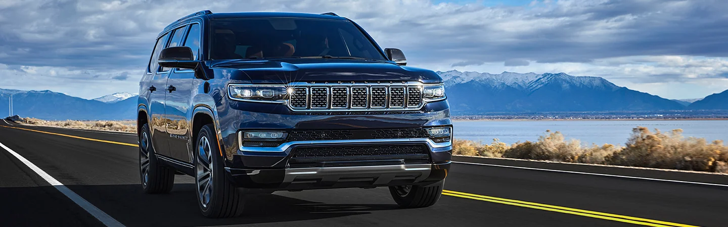 2025 Grand Wagoneer driving on a coastline with a mountains view