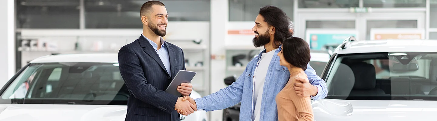shaking hands in new car showroom