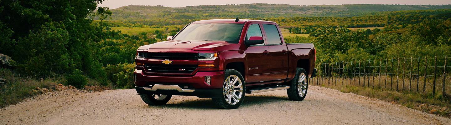 A red 2021 Chevy Silverado 1500 parked on a dirt road