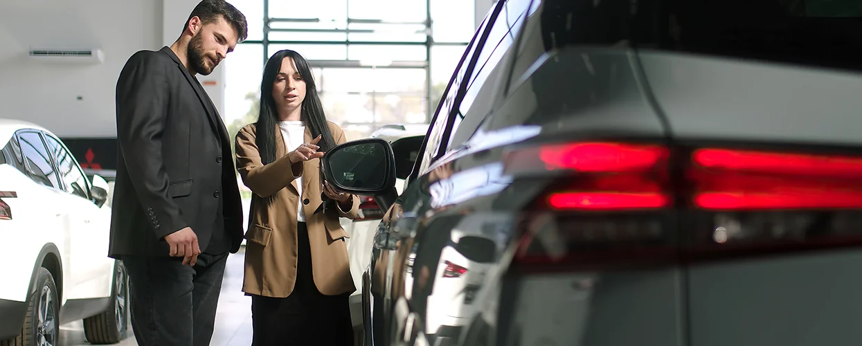 Sales person showing custoemr a new car