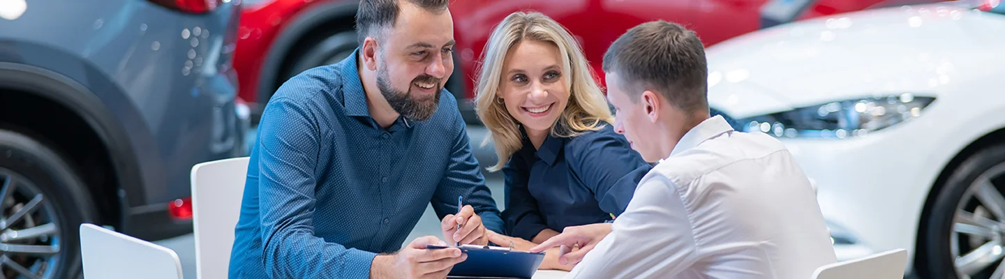 couple speaking with car salesperson about a car purchase financing
