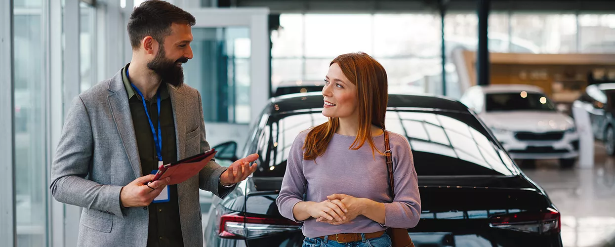 Car salesman showing a customer around a Subaru dealership