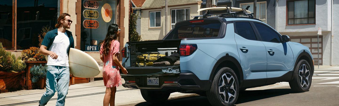 2022 Hyundai Santa Cruz loading with a surfboard man and women