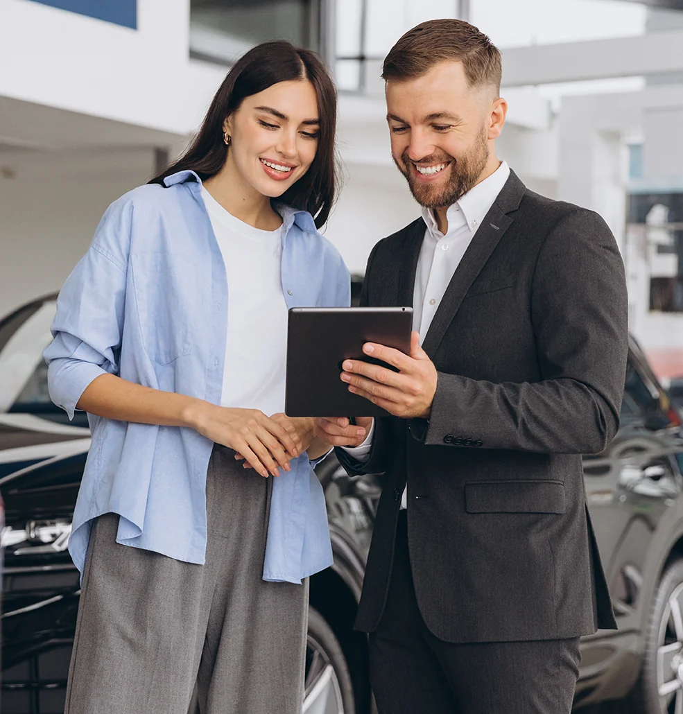 Smiling customer and sales person going over the specs of a 2026 Jeep Gladiator