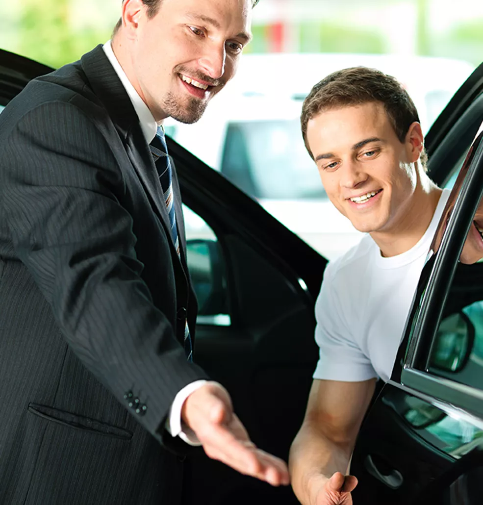Car salesman showing someone a new vehicle