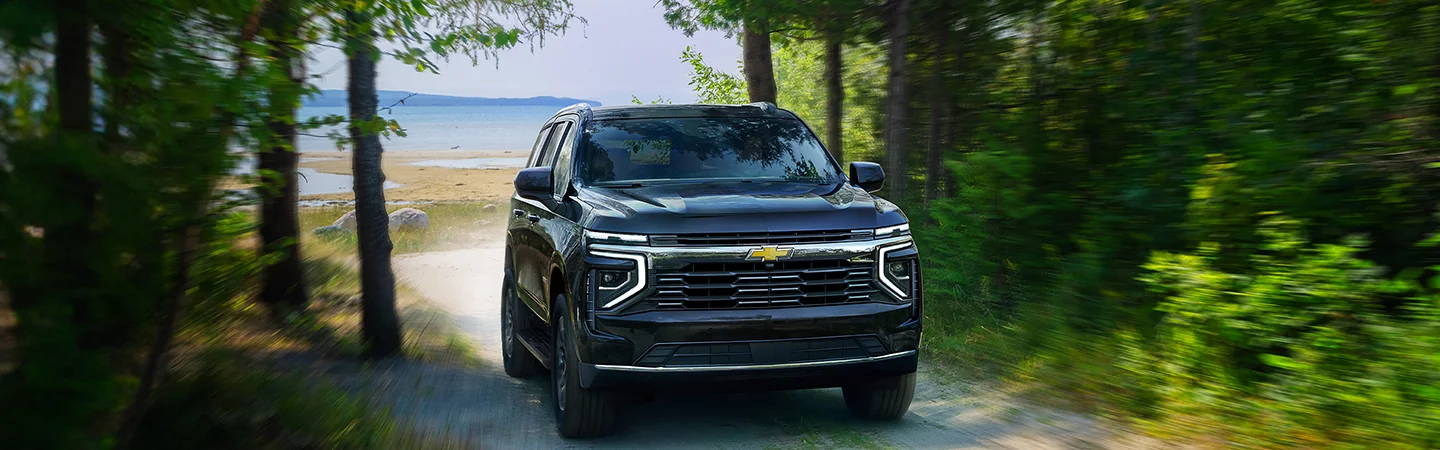 Front view of a 2025 Chevrolet Tahoe drivingup a sand path away from the beach