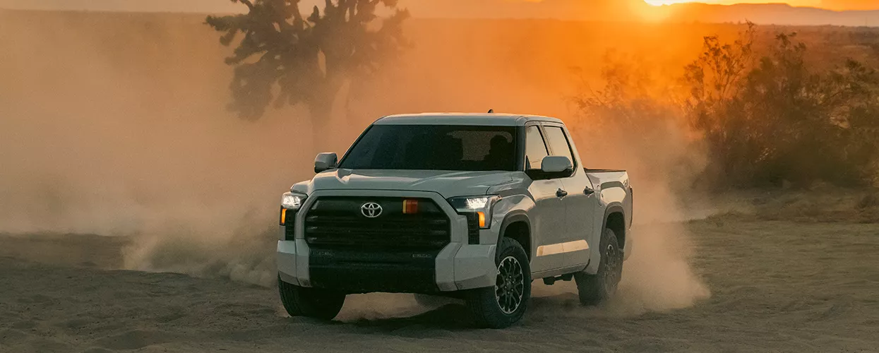 Toyota Truck driving off road with a sunset in the background