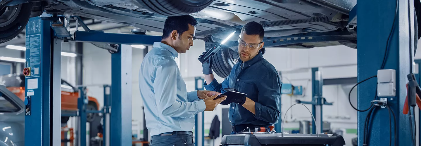 Service mechanics looking at a vehicle
