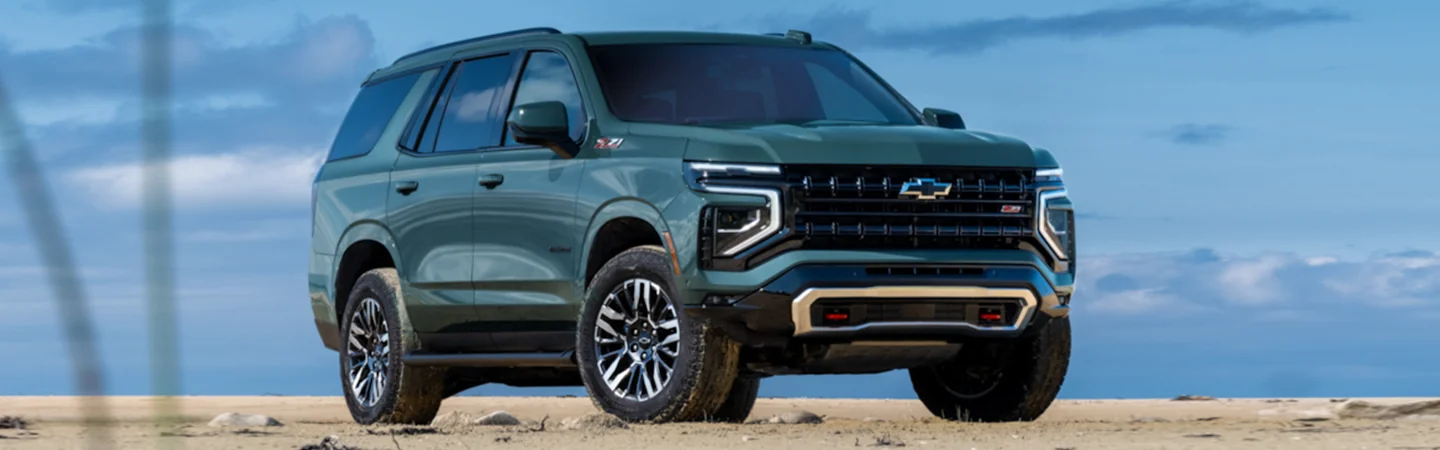 Front side view of a 2025 Chevrolet Suburban parked at the beach