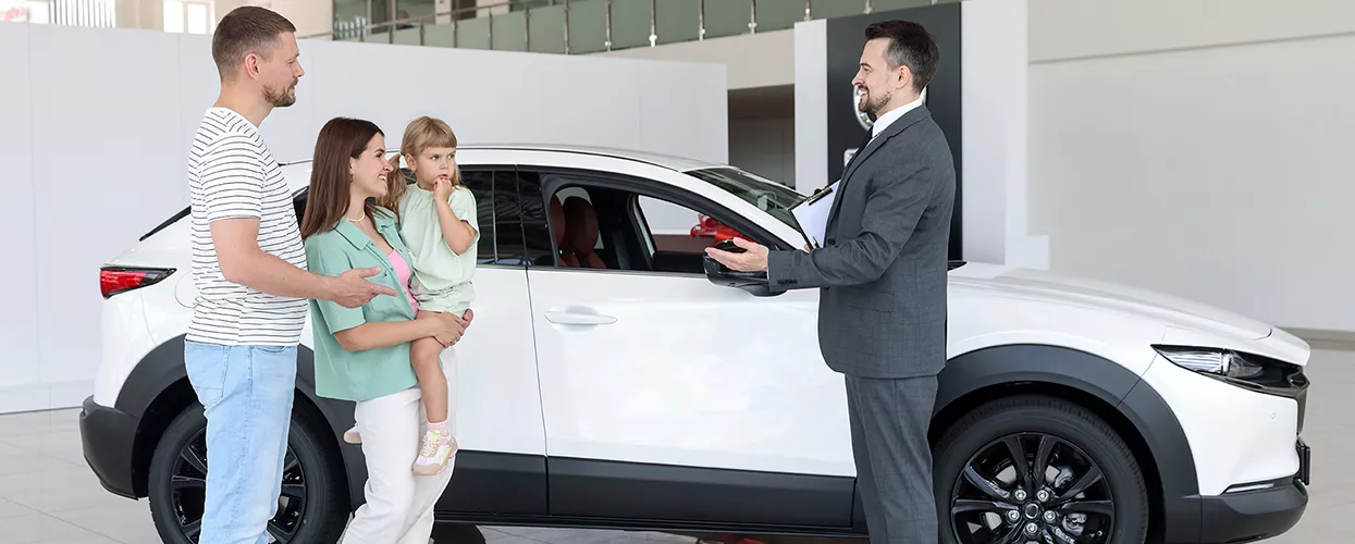 Car salesman talking to a family about a new Toyota vehicle