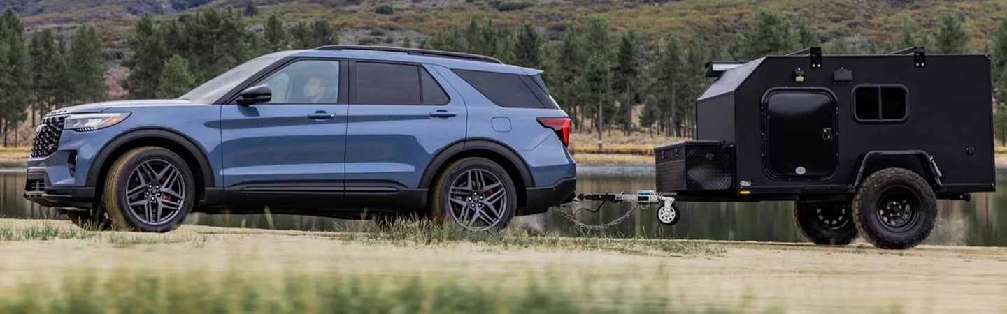 Blue Ford Explorer SUV towing camper