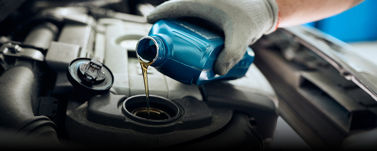 oil being poured into an engine by a mechanic