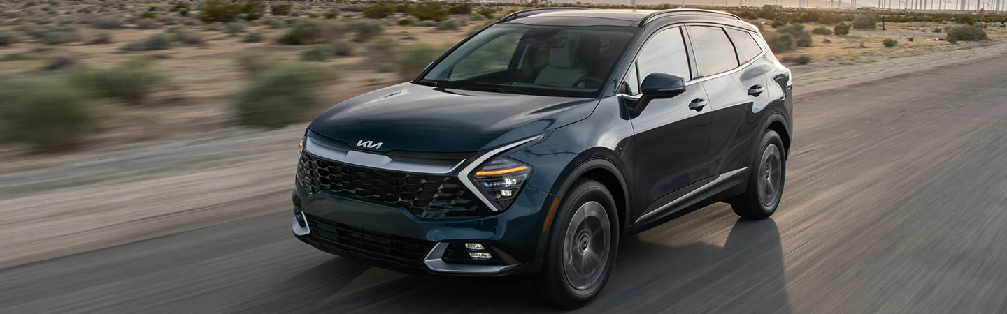 blue 2025 Kia Sportage Hybrid driving on highway