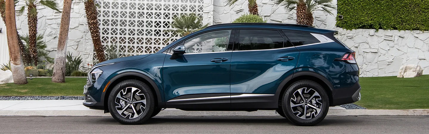 blue 2025 Kia Sportage Hybrid side view in parking