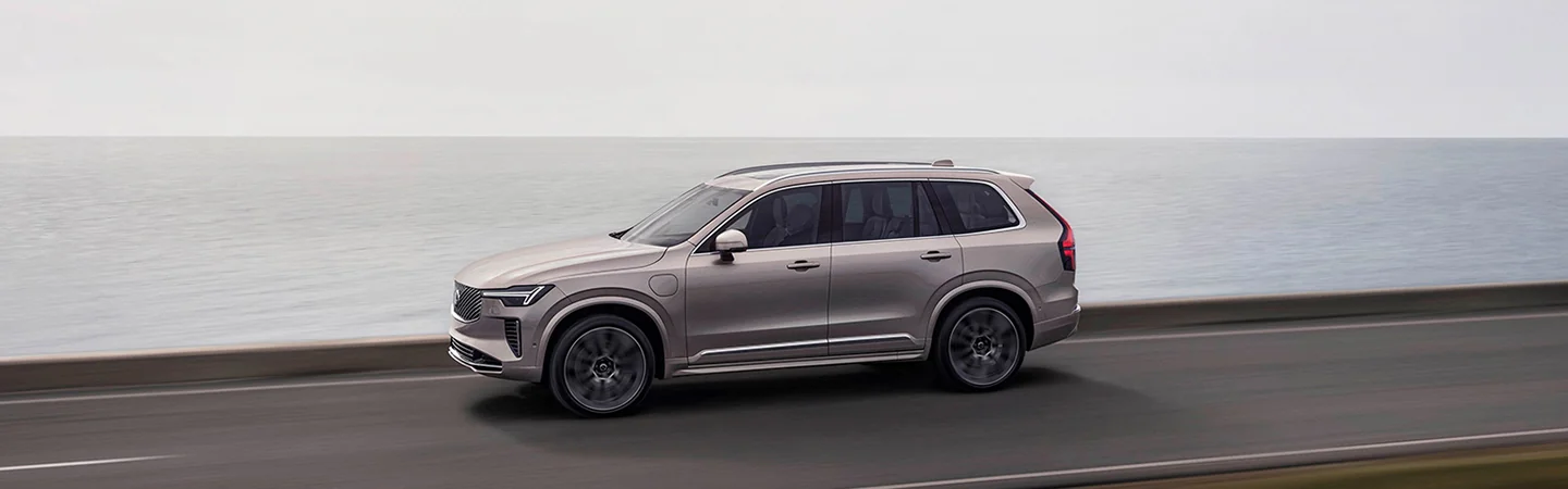 2025 Volvo XC90 Core in motion driving along the shore