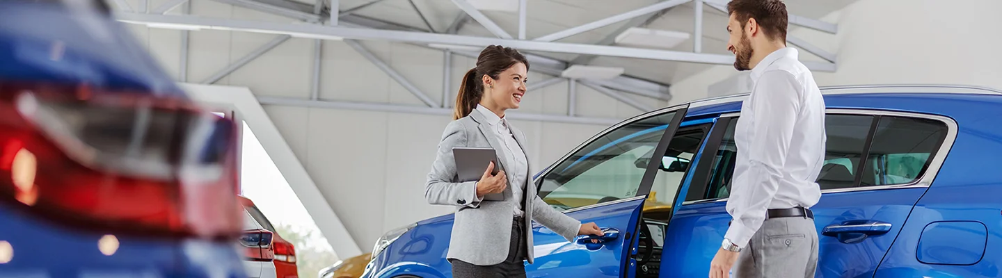 Sales person showing customer a new car