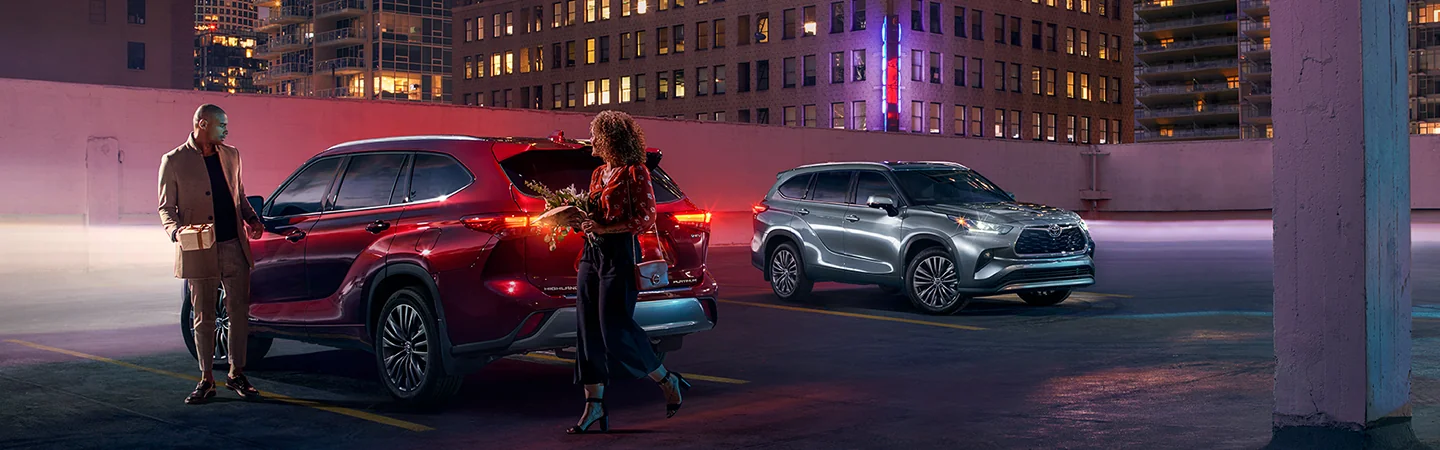People parking a 2025 Toyota Highlander in a parking lot on their way to a party